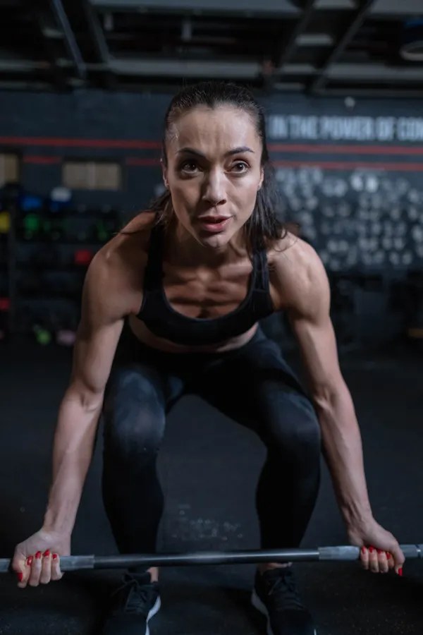 Woman training with a barbell in a gym