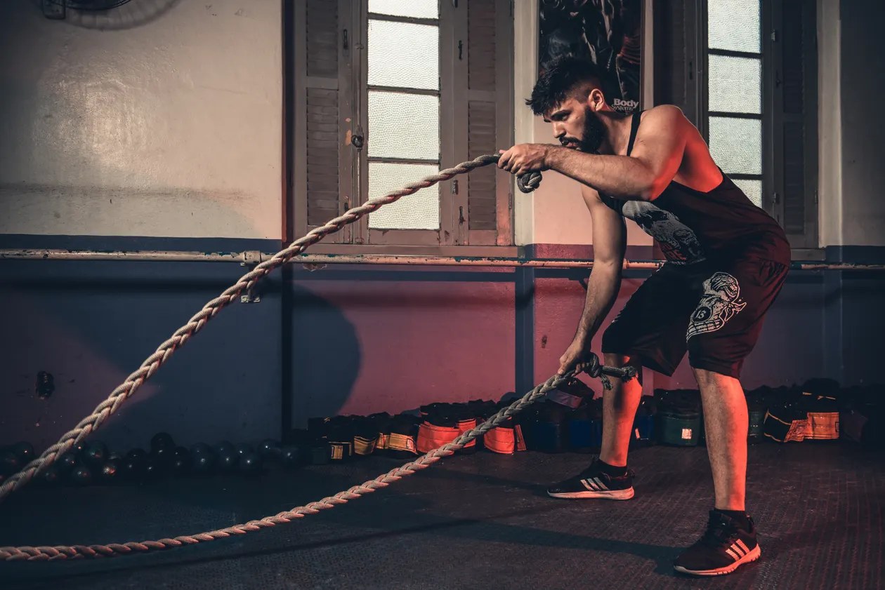 Male athlete training with battle ropes